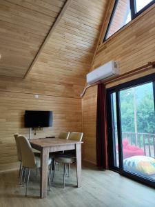 a dining room with a table and chairs and a tv at Adrasan Twin Aparts in Kumluca