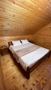 a bedroom with a bed in a wooden room at Порядна Ґаздиня in Yaremche