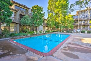 a swimming pool in the courtyard of a apartment building at Waterfront Long Beach Condo with Pool Access! in Long Beach