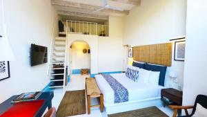 a small room with a bed and a ladder at Hotel El Ciruelo, Tepoztlán in Tepoztlán