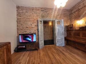 salon z telewizorem i ceglaną ścianą w obiekcie Stylowy Apartament Retro w Poznaniu