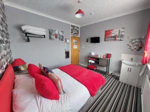 een slaapkamer met een groot bed met rode kussens bij Westbrook Lodge Guest House in Margate