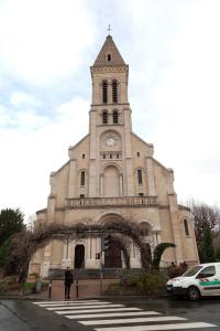 una iglesia con una torre de reloj en un edificio en Élégant appartement aux portes de paris, en Saint-Ouen