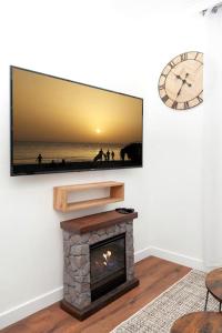 Una sala de estar con chimenea y TV de pantalla plana. en Élégant appartement aux portes de paris, en Saint-Ouen
