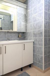 a bathroom with a white sink and a shower at Élégant appartement aux portes de paris in Saint-Ouen