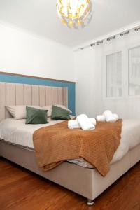 a bedroom with a large bed with a blanket on it at Élégant appartement aux portes de paris in Saint-Ouen