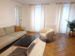 een woonkamer met een bank en een stoel bij Champs Elysées Luxury appartment in Parijs