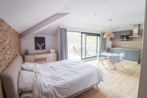 1 dormitorio con 1 cama y 1 mesa con sillas en Recreatiedomein Warredal - The Lodge, en Neeroeteren