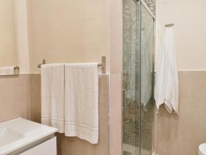 y baño con ducha, toallas y lavamanos. en Aqua Pompeiana, en Scafati