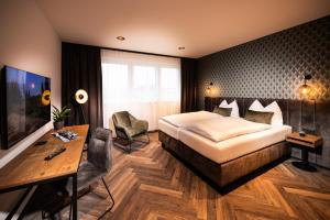 a hotel room with a bed and a desk at Zeit und Raum Hotel - Self Check-In in Eggelsberg