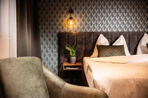 um quarto de hotel com uma cama e uma cadeira em Zeit und Raum Hotel - Self Check-In em Eggelsberg