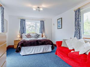 a bedroom with a bed and a red couch at 3 Bed in Welsh Newton Common 52149 in Welsh Newton Common