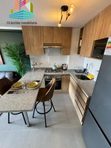 uma cozinha com uma mesa e algumas cadeiras num quarto em NUEVO E IMPECABLE A PASOS DEL MAR em Antofagasta