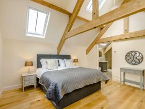 ein Schlafzimmer mit einem großen Bett und Holzböden in der Unterkunft 4 Bed in Bedale 80704 in Finghall