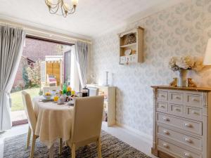 a dining room with a table with chairs and a dresser at 3 Bed in Dereham 87159 in East Dereham