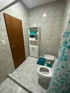 uma casa de banho com um WC branco e uma porta castanha em LU DORMIS Alquiler Temporario em Corrientes