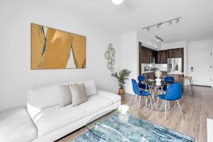 - un salon avec un canapé blanc et des fauteuils bleus dans l'établissement Sleek Doral Retreat 1 Bed Oasis With Free Parking, à Hialeah Gardens