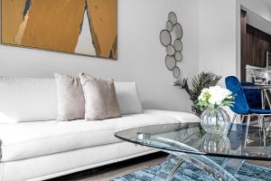 - un salon avec un canapé blanc et une table en verre dans l'établissement Sleek Doral Retreat 1 Bed Oasis With Free Parking, à Hialeah Gardens