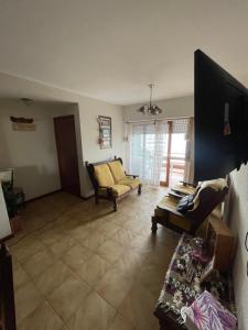 sala de estar con sofá y TV en Semipiso Frente al Mar en San Bernardo