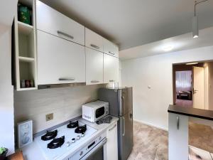 a kitchen with a white stove and a microwave at Sal Apart in Timişoara