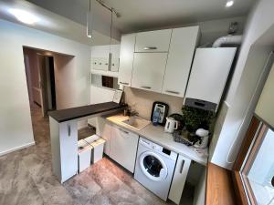 a kitchen with white cabinets and a washing machine at Sal Apart in Timişoara