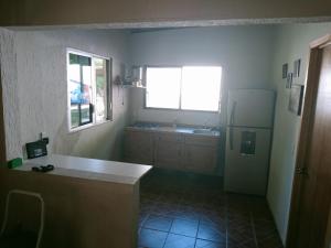 a kitchen with a counter and a refrigerator and a window at Quinta Nova Sky in Tamasopo