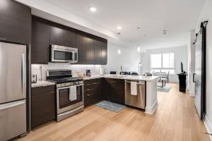 a kitchen with stainless steel appliances and wooden cabinets at Hollywood Walk of Fame! 1BD Pool/Parking/Balcony in Los Angeles