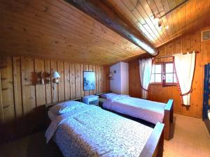 een slaapkamer met 2 bedden in een houten hut bij Chalet Le Sapin in Le Grand-Bornand