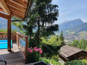a wooden deck with a view of the mountains at Chalet Le Sapin in Le Grand-Bornand