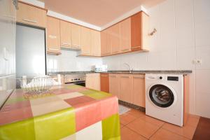 uma cozinha com uma mesa colorida e uma máquina de lavar roupa em Apartamento frente al mar en A Illa de Arousa em Isla de Arosa