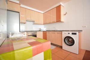 a kitchen with a colorful table and a washing machine at Apartamento frente al mar en A Illa de Arousa in Isla de Arosa
