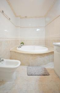 uma casa de banho com uma banheira, um WC e um lavatório. em Apartamento frente al mar en A Illa de Arousa em Isla de Arosa