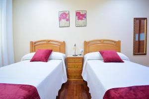 two beds sitting next to each other in a bedroom at Apartamento frente al mar en A Illa de Arousa in Isla de Arosa