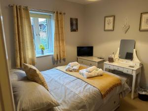 1 dormitorio con cama, escritorio y espejo en Abbotsleigh Rest - close to Glastonbury Abbey en Glastonbury