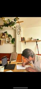 una donna seduta a una scrivania che scrive su un foglio di Coco Surfhouse - Coworking Coliving a Corralejo