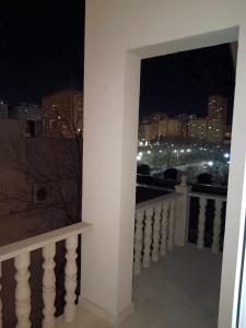 a balcony with a view of a city at night at soprano guest house in Baku