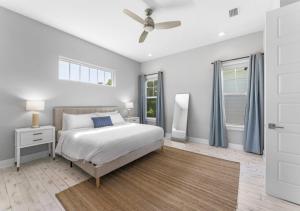 een slaapkamer met een bed en een plafondventilator bij Luxurious Ocean View 3BD House In Jacksonville in Jacksonville Beach