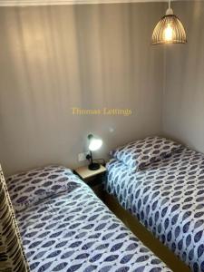 2 nebeneinander sitzende Betten in einem Schlafzimmer in der Unterkunft Cosy 2 Bed Chalet in Great Yarmouth