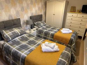 a room with two beds with towels on them at Abbotsleigh Rest - close to Glastonbury Abbey in Glastonbury