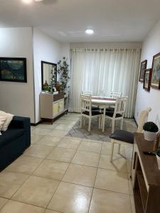 ein Wohnzimmer mit einem Sofa, einem Tisch und Stühlen in der Unterkunft apartamento 2 quartos quadra do mar centro in Balneário Camboriú