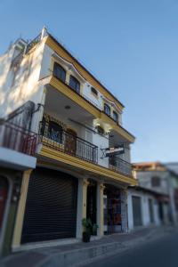 a yellow and white building with a balcony at Hotel Los Manantiales in Panajachel