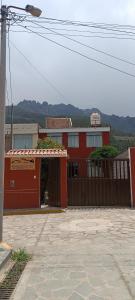 un edificio rojo con una puerta y una valla en Hospedaje Vacacional - Colca, en Chivay