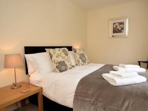 a bedroom with a bed and a table with a lamp at 3 Bed in Smarden 58544 in Smarden