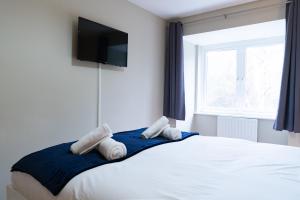 1 dormitorio con 1 cama blanca grande y ventana en Entire 4 Bed Cosy Luxury Spacious house, en Huntingdon