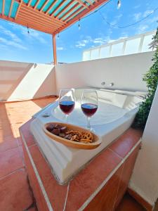 - deux verres de vin et un plateau de nourriture sur une table dans l'établissement Paraiso Teques, Casa entera con acceso al lago, à Tequesquitengo