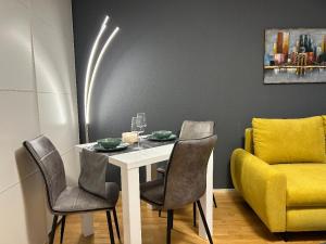 uma sala de jantar com mesa e cadeiras e um sofá amarelo em Gemütliches helles Apartment im Zentrum von Bayreuth em Bayreuth