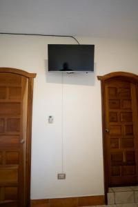 TV de pantalla plana en la parte superior de una pared blanca en Hotel Los Manantiales en Panajachel