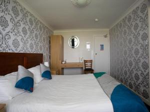 a bedroom with a large bed with blue pillows at Knowesgate Hotel B&B in Newcastle upon Tyne