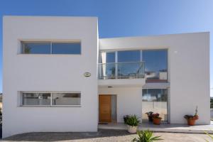 a white facade of a house with windows at Villa Oasis Chiva - Tu Lujoso Refugio con Piscina privada in Chiva