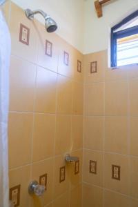 uma casa de banho com um chuveiro com azulejos laranja em Hotel Los Manantiales em Panajachel